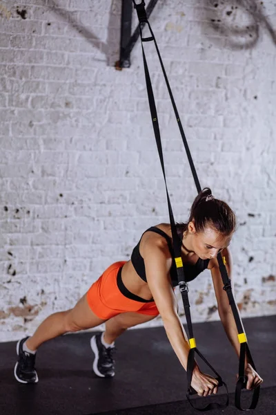 Fitness woman workout on TRX straps in gym. Crossfit style. Training TRX.  Stock Photo by ©ufabizphoto 248263970