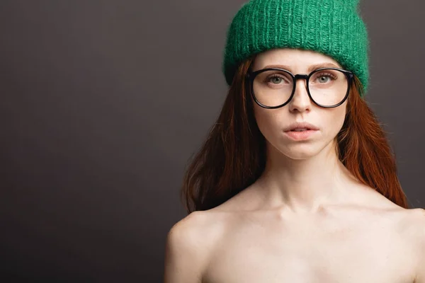 Moda rossa ragazza in maglia cappello e galsses su sfondo grigio — Foto Stock