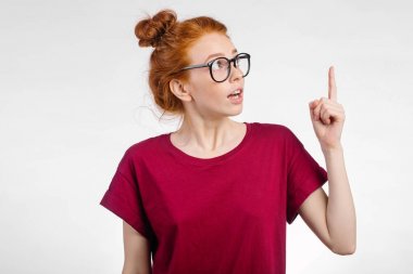 Kız gösteren kopya alanı parmak beyaz arka plan ile şaşırttı. yukarı dönük kız