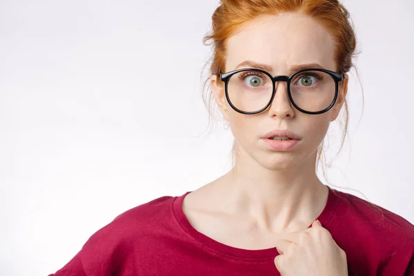 Vackra redhair flickan bär glasögon chockerande med något — Stockfoto