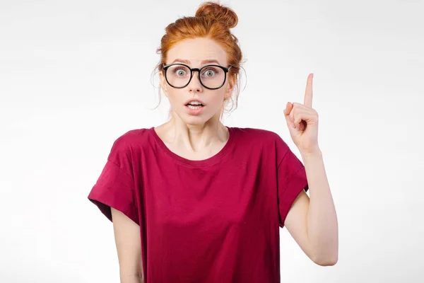 Chica sorprendida mostrando espacio de copia con el dedo fondo blanco. chica apuntando hacia arriba — Foto de Stock