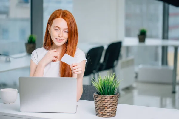 Perempuan membeli online dengan laptot dan melihat kartu kredit — Stok Foto