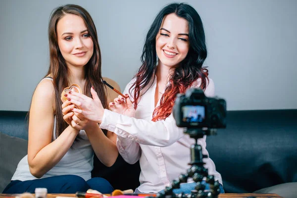 Dos mujeres jóvenes revisando productos de belleza en video blog en casa —  Fotos de Stock