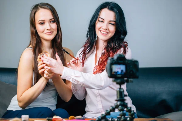 Dos mujeres jóvenes revisando productos de belleza en video blog en casa — Foto de Stock