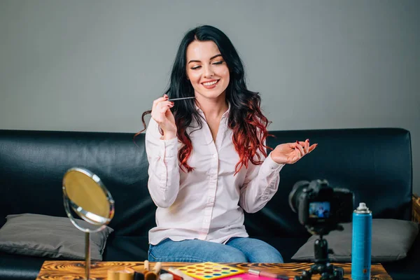 Blogger femenina con cosméticos de maquillaje grabando video en casa — Foto de Stock