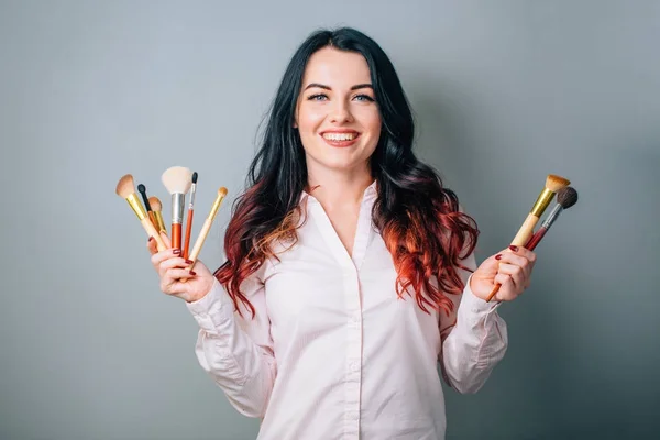 Maquillar a la artista con pinceles de maquillaje cerca de la cara. concepto de belleza — Foto de Stock