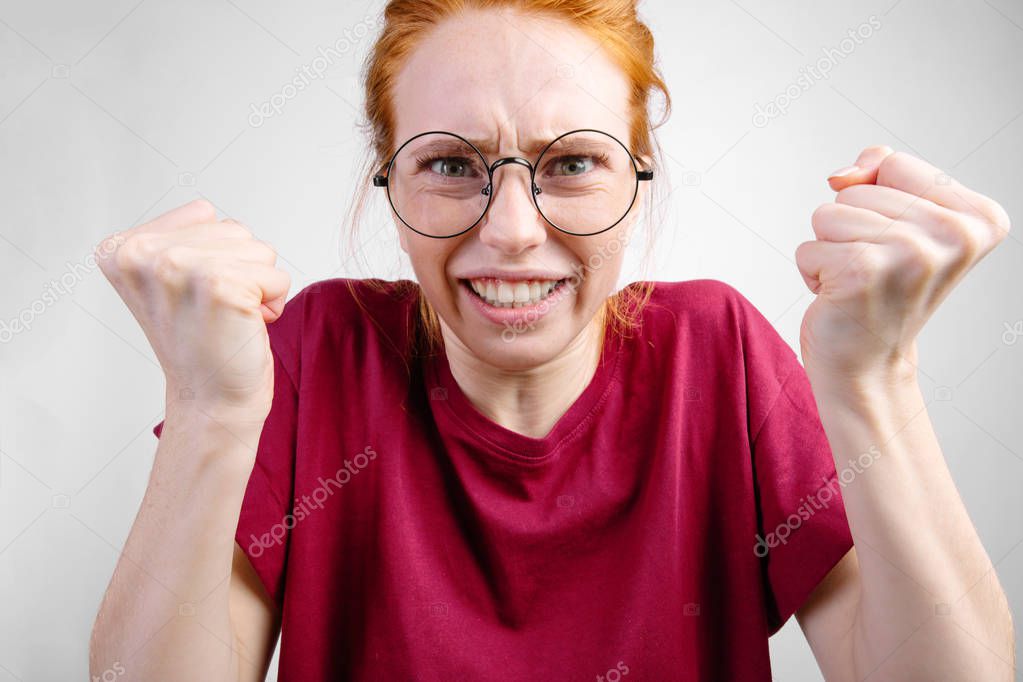 angry woman standing with raised knuckles on white background