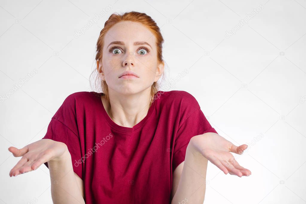 confused woman looking at camera and gesturing with hands white background