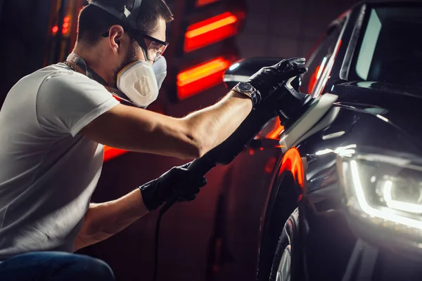 Auto detaillering - man met orbitale polijstmachine in auto reparatiewerkplaats. Selectieve aandacht. — Stockfoto