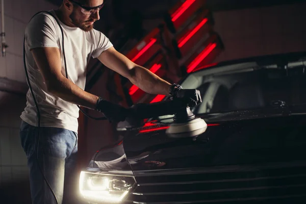 Detalles del coche - hombre con pulidor orbital en taller de reparación de automóviles. Enfoque selectivo . —  Fotos de Stock