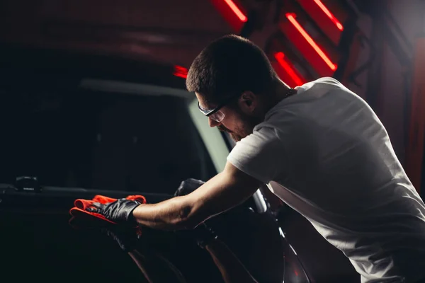 Car detailing - the man holds the microfiber in hand and polishes the car — Stock Photo, Image