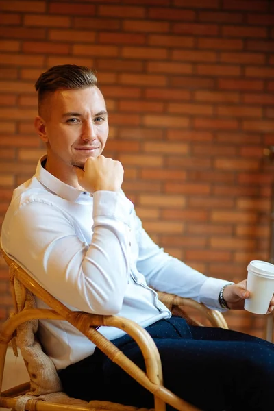 Красивий бізнесмен п'є каву вдома і дивиться камеру — стокове фото