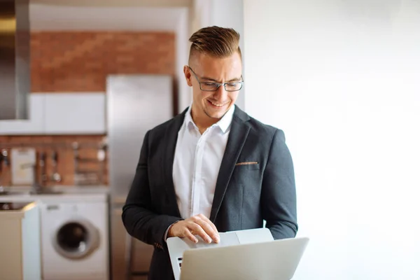 Knappe man met bril, werken met de laptop in office — Stockfoto