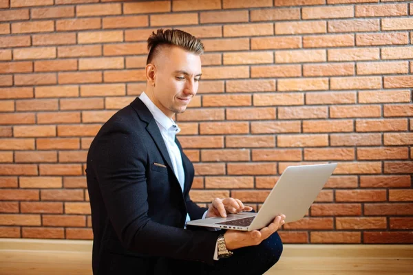 Zakenman met behulp van laptop thuis zittend op de vloer — Stockfoto