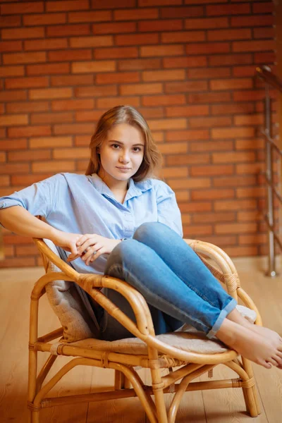 Mujer joven relajándose en una silla grande y cómoda — Foto de Stock
