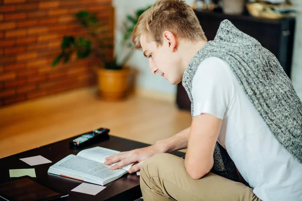 Uomo che legge libri mentre si siede divano — Foto Stock