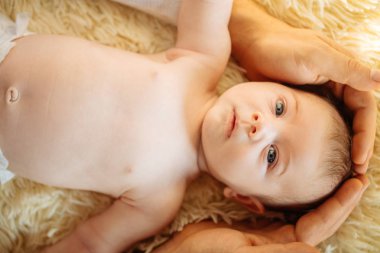 Yeni doğan bebeğin başını tutan babası ise kamera bakarak gülen aşağı yalan