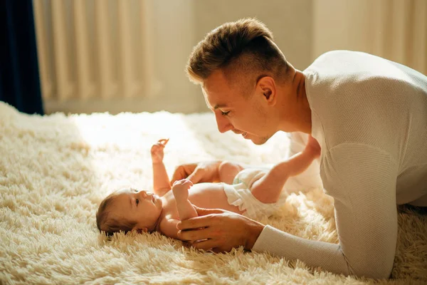 Vader spelen met schattige baby in slaapkamer — Stockfoto