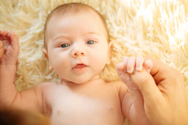Noworodka, uśmiechając się, patrząc na kamery, podczas gdy ojciec trzymając głowę w pozycji leżącej — Zdjęcie stockowe