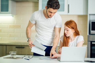 belgeler bakarken çift evde aile içi faturaları hakkında tartışıyor