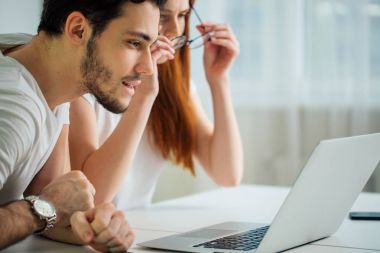 Internet birlikte oturma masa ve gülümseyen ve okuma ekranında tarama Çift