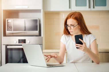 genç iş kadını bir smartphone kullanarak ve ofiste çalışırken gülümseyen