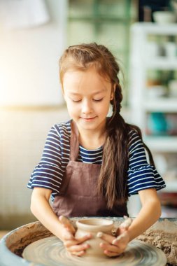 Çocuk kil pot sculpts. çömlekçi çarkında modelleme.