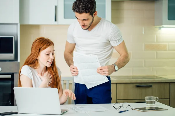 Couple discussing about domestic bills at home while looking at documents — Stock Photo, Image