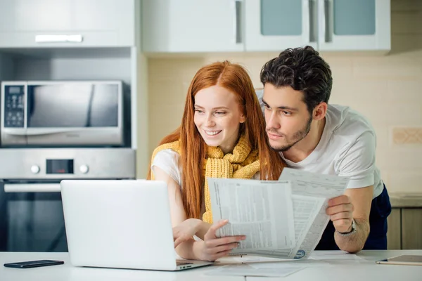 Gelukkig paar thuis betalen rekeningen met laptop — Stockfoto