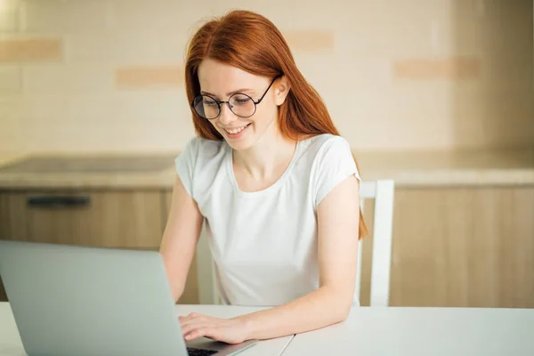 Улыбающаяся женщина с ноутбуком в домашнем офисе — стоковое фото