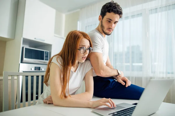 Geschocktes Paar mit offenem Mund online mit Laptop im heimischen Wohnzimmer — Stockfoto
