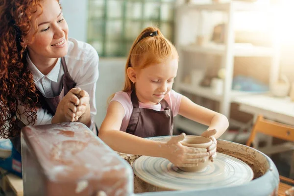 Kızıl saçlı kız bir çanak çömlek çarkı bir sürahi yapmak