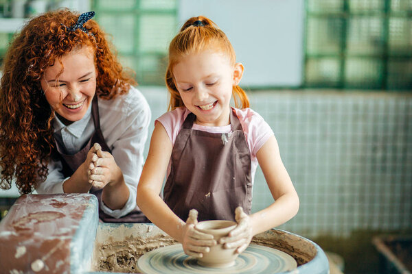 teacher and student make pitcher of pottery wheel