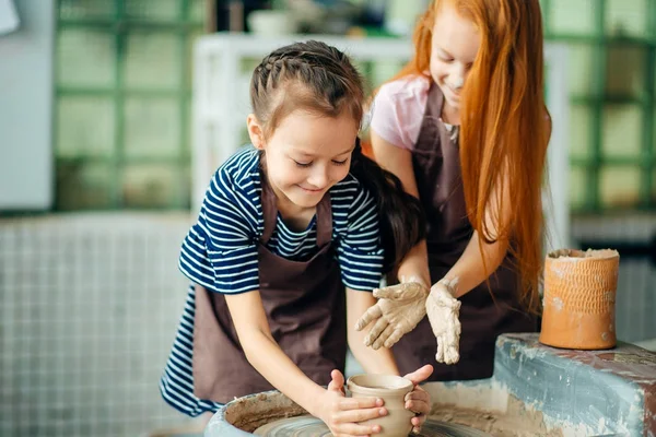 Processo di lavorazione con ruota in ceramica di argilla. Due ragazze che fanno ceramiche in studio — Foto Stock