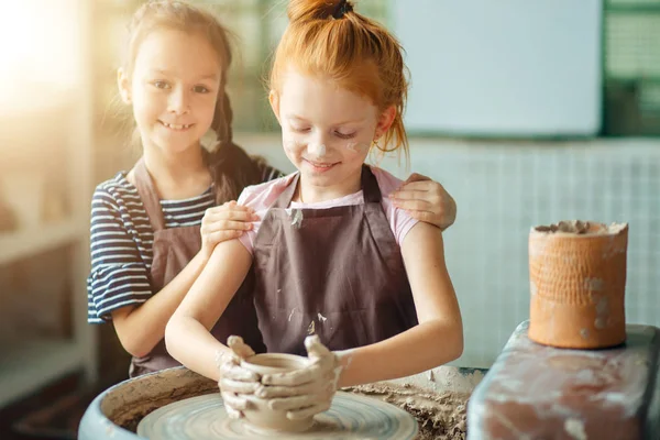 Processo di lavorazione con ruota in ceramica di argilla. Due ragazze che fanno ceramiche in studio — Foto Stock