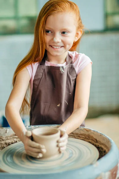 Rude dziecko rzeźbi z gliny garnek. warsztaty na temat modelowania potters wheel. — Zdjęcie stockowe