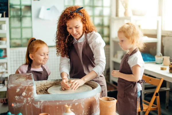 Anne ve iki Kızıl saçlı kızı kil çömlek çarkı fincanla yapılan