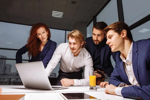 Lachende vrouwelijke en knappe mannelijke collega's zitten aan tafel, kijken naar Laptop — Stockfoto