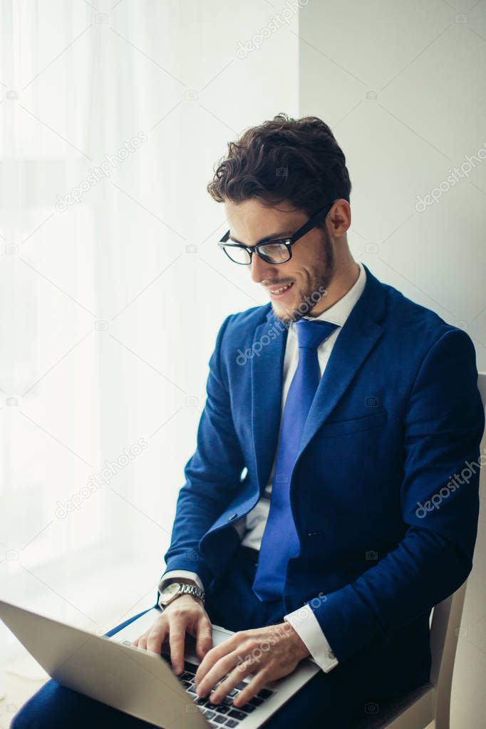 finance market analyst in eyeglasses working at sunny office on laptop