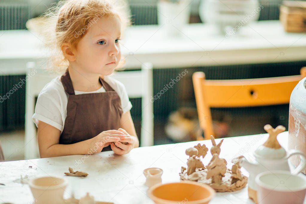 girl looking sideway near clay toys at table