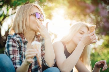 iki genç kadın yeme dondurma külah onların tatil sırasında sıcak yaz gününde