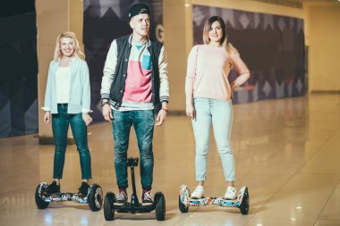 erkek ve iki kadın Hoverboard alışveriş merkezinde sürme