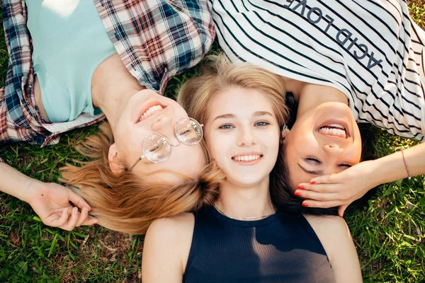 Je passe du bon temps avec des amis. groupe d'étudiants couchés sur l'herbe profiter — Photo