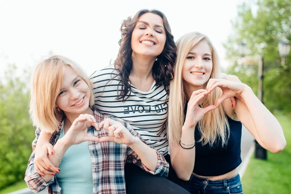 Tre kvinnliga vänner att göra hjärta form från hand — Stockfoto