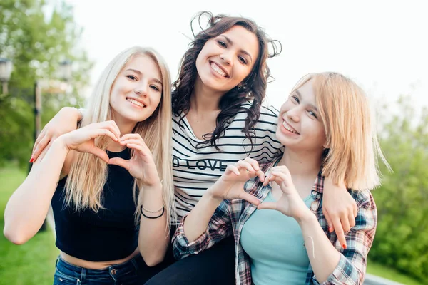 Three female friends making heart shape from hand — Stock Photo, Image