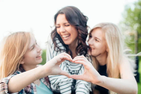 Vuxna systrar i en park på underbar dag gör hjärtat gest — Stockfoto