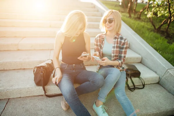 Två vänner titta på bilder på en mobiltelefon — Stockfoto