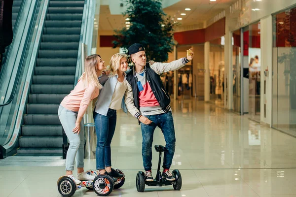 Nieuwe moderne technologieën. drie mensen op hoverboard doen selfie — Stockfoto