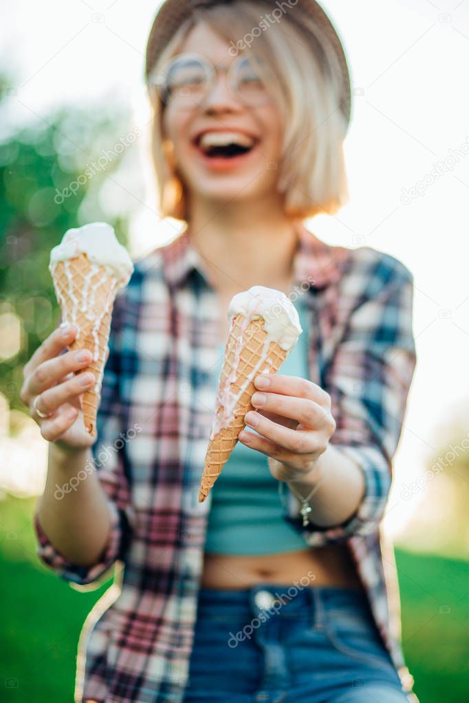 Outdoor closeup fashion portrait of young hipster crazy girl eating ice cream