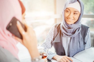 Müslüman kadın üzerinde Break kullanarak cep telefonu içinde kafe